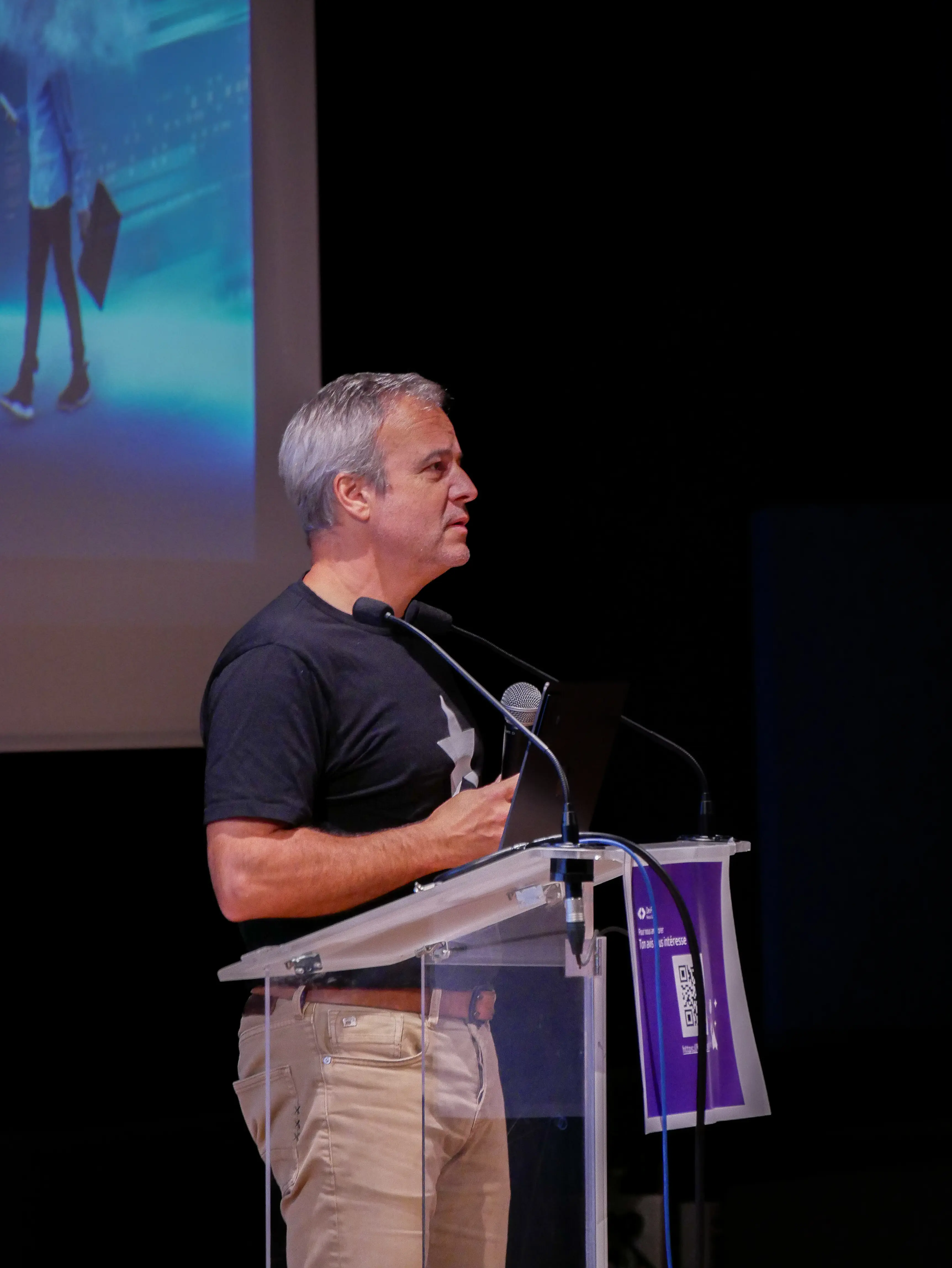 Speaker presenting with scenic coastal view visible through large windows